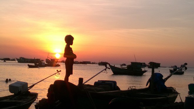 Cậu bé đứng ngắm hoàng hôn ở bến cảng Hòn Thơm. Cậu bé đứng ngắm hoàng hôn ở bến cảng Hòn Thơm.